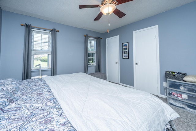 carpeted bedroom featuring a textured ceiling and a ceiling fan