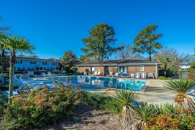 community pool featuring a patio and fence