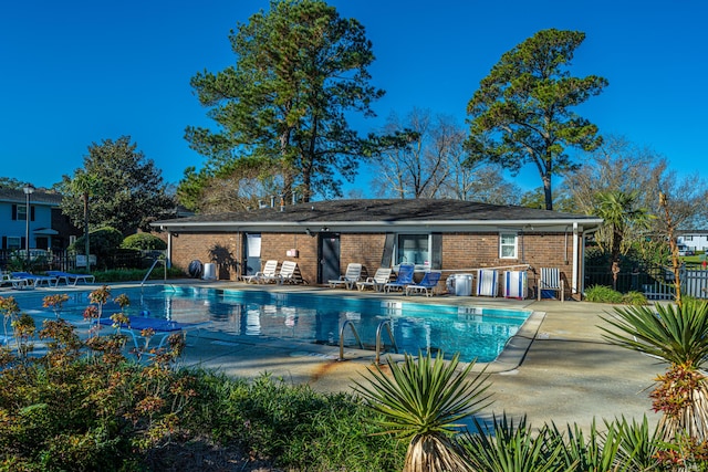 pool with a patio and fence