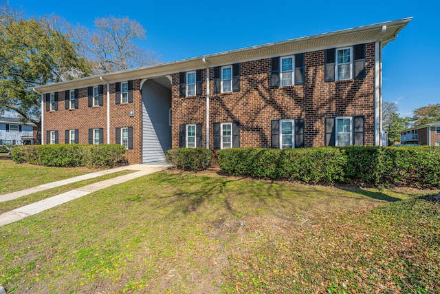 view of front of home with brick siding and a front yard