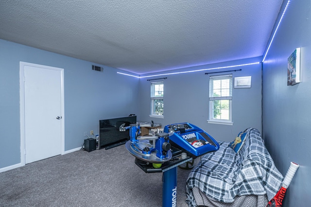 rec room featuring visible vents, a textured ceiling, baseboards, and carpet floors