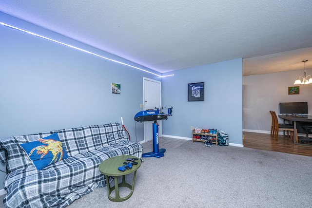 interior space featuring a chandelier, carpet flooring, a textured ceiling, and baseboards