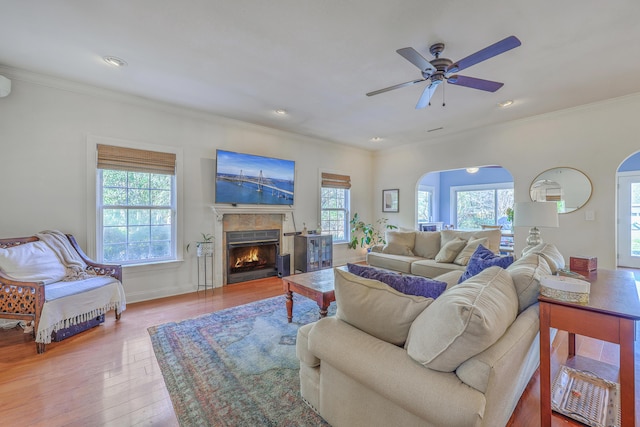 living room featuring a healthy amount of sunlight, ornamental molding, and wood-type flooring