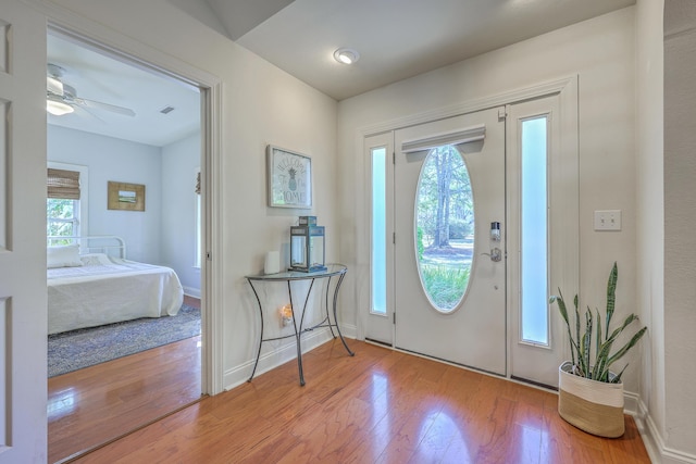 entryway featuring a ceiling fan, hardwood / wood-style flooring, a healthy amount of sunlight, and baseboards