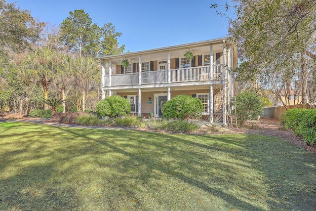 view of front of home with a balcony and a front lawn