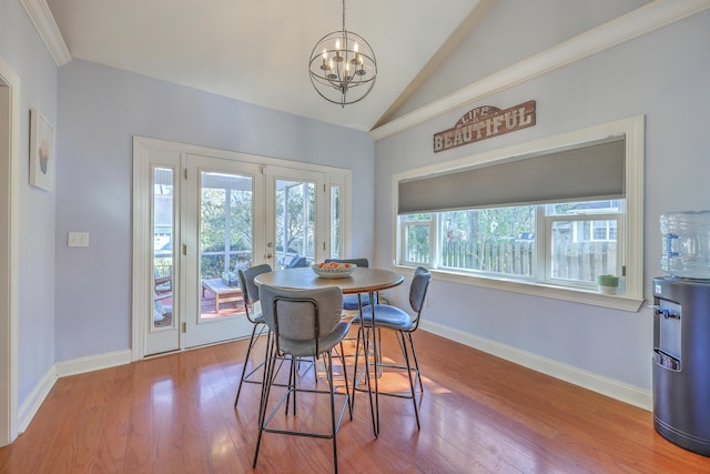 dining area featuring a notable chandelier, wood finished floors, french doors, baseboards, and lofted ceiling