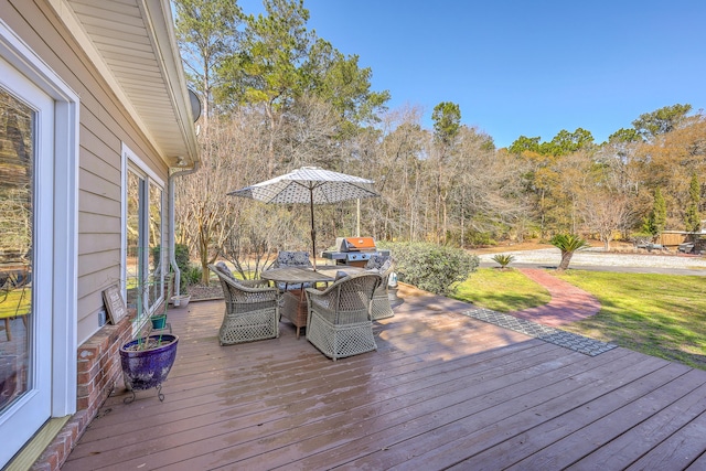 deck featuring area for grilling, outdoor dining area, and a yard