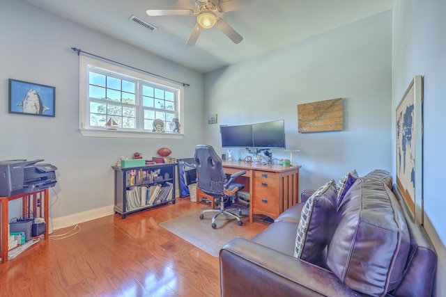 home office with visible vents, wood finished floors, baseboards, and ceiling fan