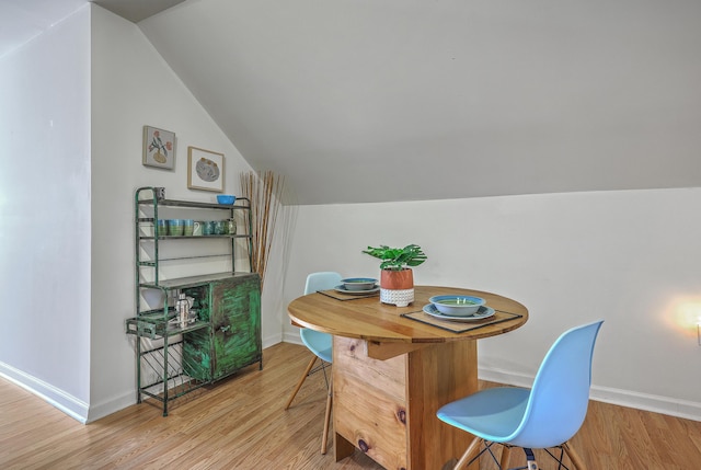 dining room with lofted ceiling, baseboards, and wood finished floors