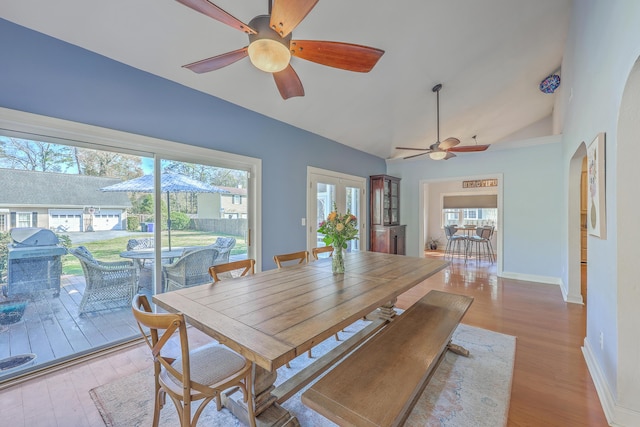 dining room featuring lofted ceiling, light wood finished floors, a ceiling fan, and a wealth of natural light