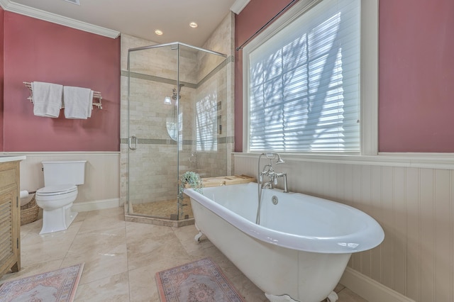 bathroom with wainscoting, toilet, a shower stall, and a freestanding tub