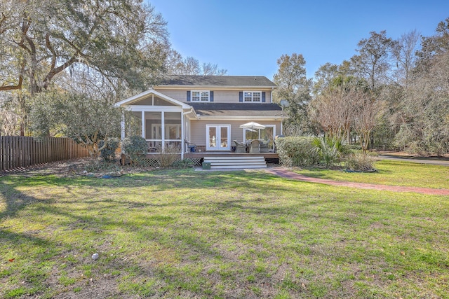 back of property featuring a lawn, french doors, a sunroom, and fence