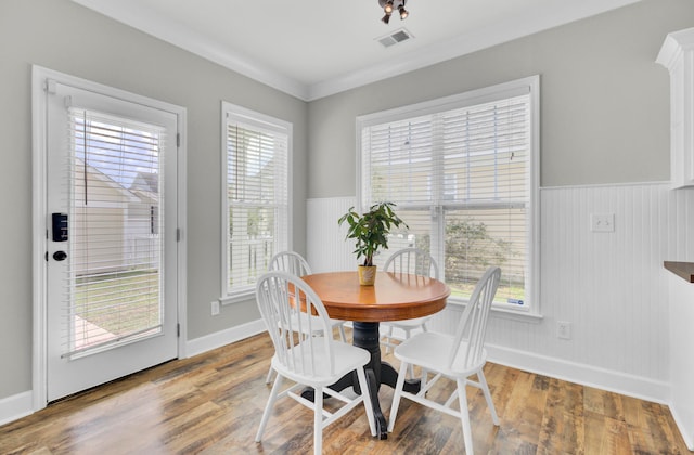 dining area featuring crown molding, hardwood / wood-style floors, and a wealth of natural light