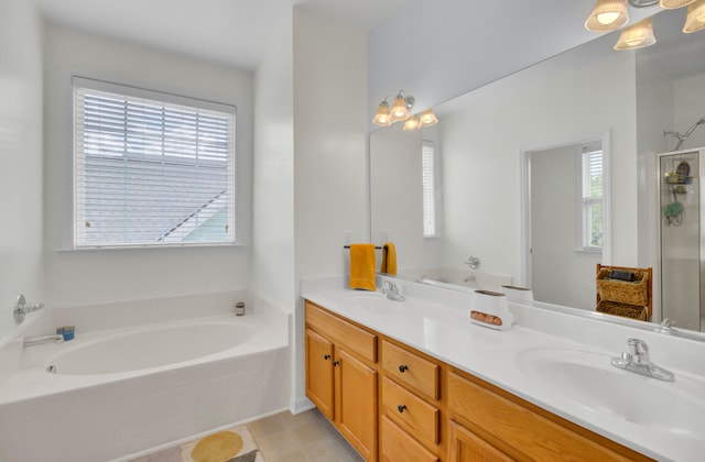 bathroom featuring independent shower and bath, vanity, and plenty of natural light