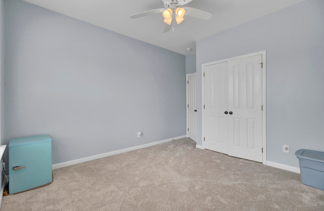 interior space featuring light carpet and ceiling fan