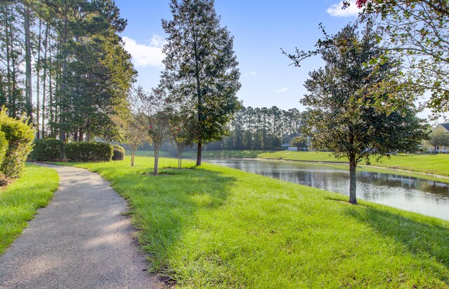 view of home's community featuring a lawn and a water view