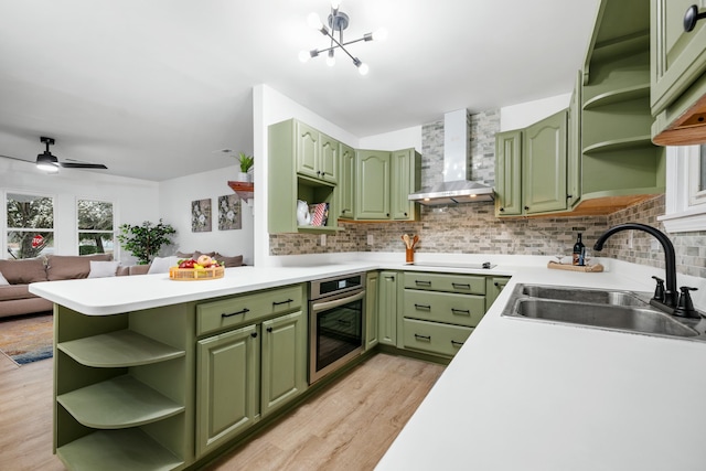 kitchen featuring green cabinets, open shelves, and wall chimney exhaust hood