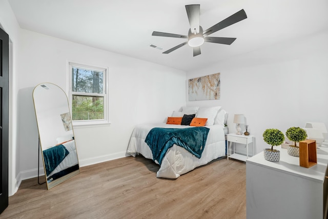 bedroom with light wood-type flooring, baseboards, visible vents, and ceiling fan