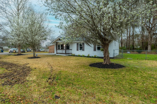 view of front of property featuring brick siding, a front lawn, and fence