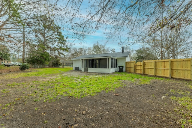 back of property featuring a sunroom and a fenced backyard