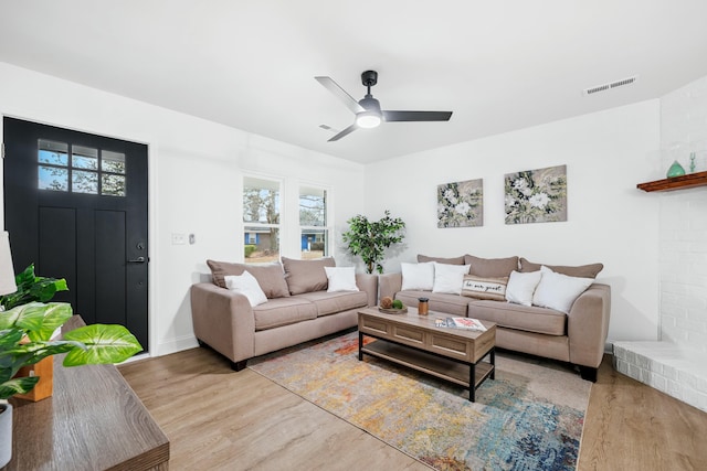 living area featuring a ceiling fan, visible vents, and wood finished floors