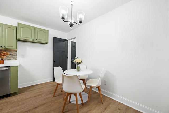 dining space with baseboards, light wood-style floors, and an inviting chandelier