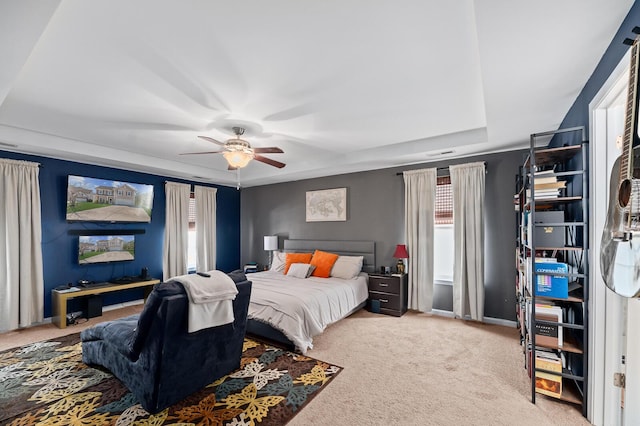 bedroom with carpet, ceiling fan, and a raised ceiling