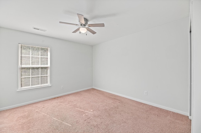 carpeted spare room with ceiling fan, visible vents, and baseboards