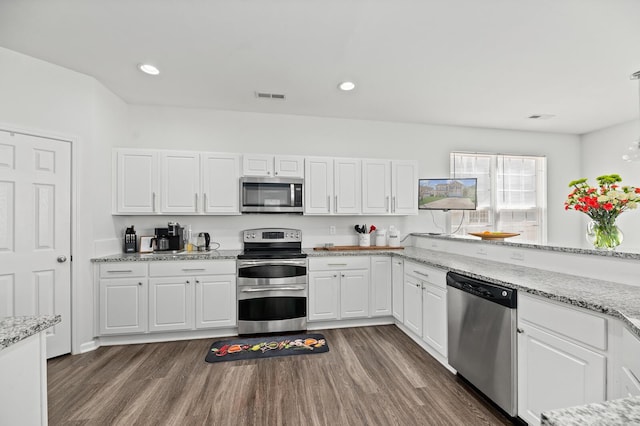 kitchen with visible vents, dark wood-style floors, appliances with stainless steel finishes, white cabinetry, and recessed lighting