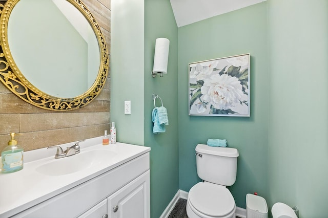 bathroom featuring toilet, vanity, and baseboards