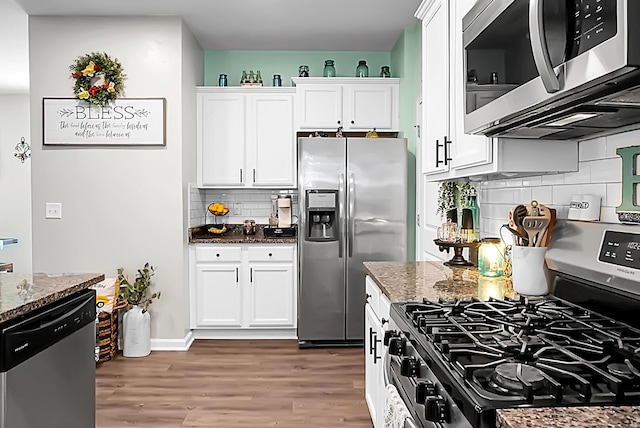 508 Glady Rd, Moncks Corner, SC 29461 - kitchen featuring appliances with stainless steel finishes, dark stone counters, backsplash, white cabinetry, and wood finished floors