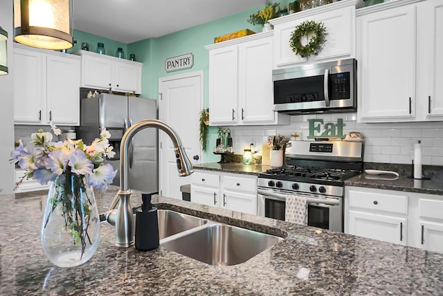 508 Glady Rd, Moncks Corner, SC 29461 - kitchen with appliances with stainless steel finishes, white cabinetry, tasteful backsplash, dark stone countertops, and a sink