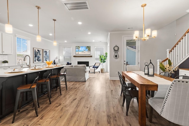 403 Cool Bend Ln, Summerville, SC 29486 - dining space with light wood finished floors, a chandelier, ornamental molding, a fireplace, and recessed lighting
