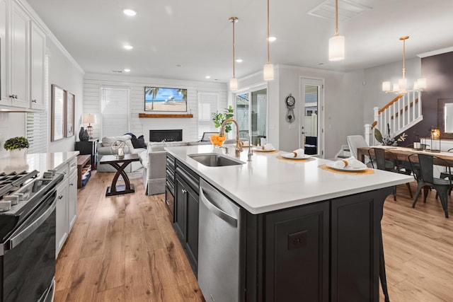 403 Cool Bend Ln, Summerville, SC 29486 - kitchen with stainless steel dishwasher, a sink, black gas stove, a fireplace, and white cabinetry