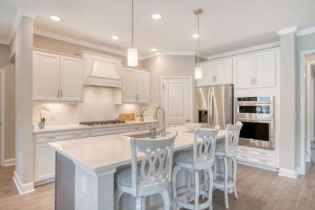 3173 Hugh Bennett Dr, Johns Island, SC 29455 - kitchen with custom exhaust hood, appliances with stainless steel finishes, a center island with sink, a kitchen breakfast bar, and light wood-type flooring
