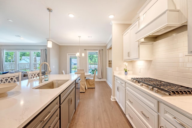 3173 Hugh Bennett Dr, Johns Island, SC 29455 - kitchen featuring stainless steel gas stovetop, a sink, light wood-style floors, plenty of natural light, and crown molding