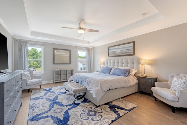 3173 Hugh Bennett Dr, Johns Island, SC 29455 - bedroom featuring a tray ceiling, multiple windows, ornamental molding, light wood-type flooring, and ceiling fan