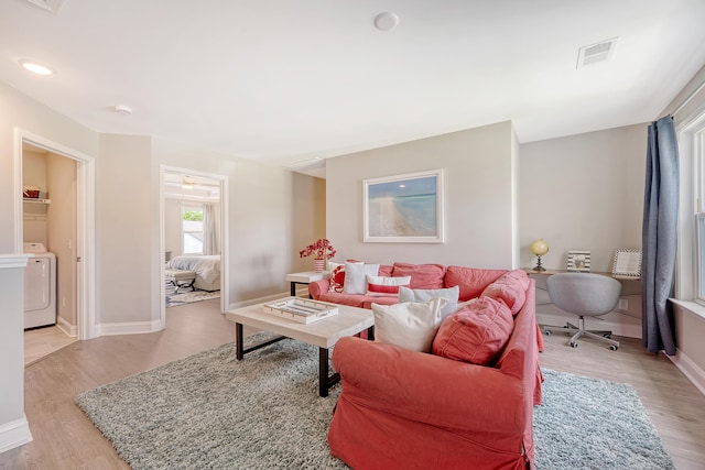 3173 Hugh Bennett Dr, Johns Island, SC 29455 - living room featuring washer / clothes dryer, light wood finished floors, and baseboards