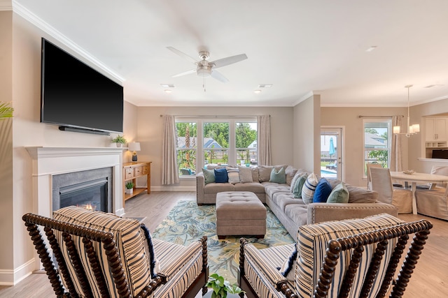 3173 Hugh Bennett Dr, Johns Island, SC 29455 - living area with light wood-style floors, a ceiling fan, crown molding, a glass covered fireplace, and baseboards