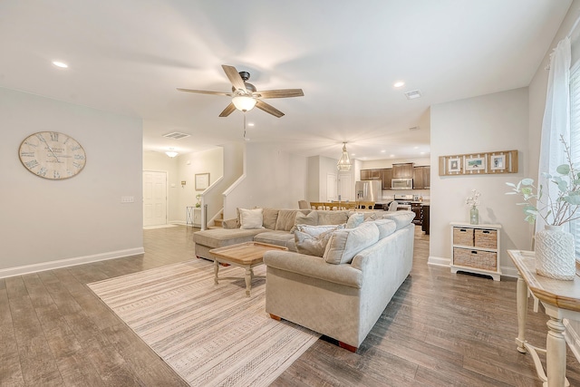living area featuring visible vents, baseboards, stairway, recessed lighting, and a ceiling fan