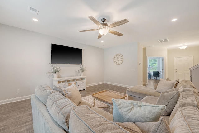 living room with baseboards, ceiling fan, wood finished floors, and visible vents