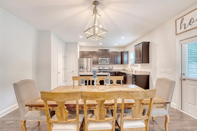 dining area featuring an inviting chandelier, baseboards, recessed lighting, and light wood finished floors