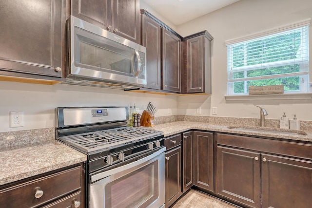 kitchen with a sink, light countertops, dark brown cabinetry, and stainless steel appliances