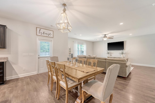 dining space featuring baseboards, ceiling fan with notable chandelier, recessed lighting, and wood finished floors