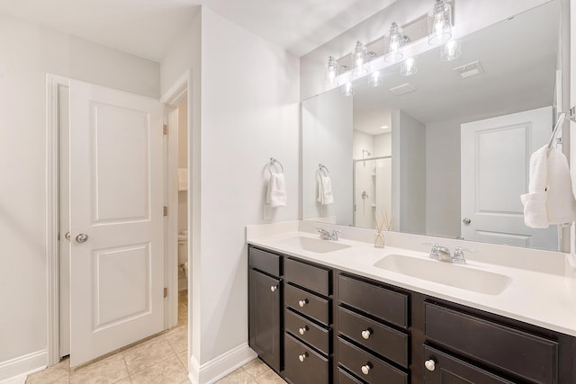 bathroom with double vanity, baseboards, a sink, and tile patterned floors