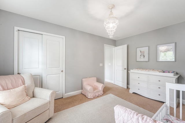 bedroom featuring a closet, baseboards, light carpet, and an inviting chandelier