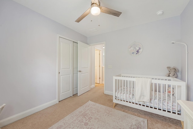 carpeted bedroom with baseboards, ceiling fan, and a closet