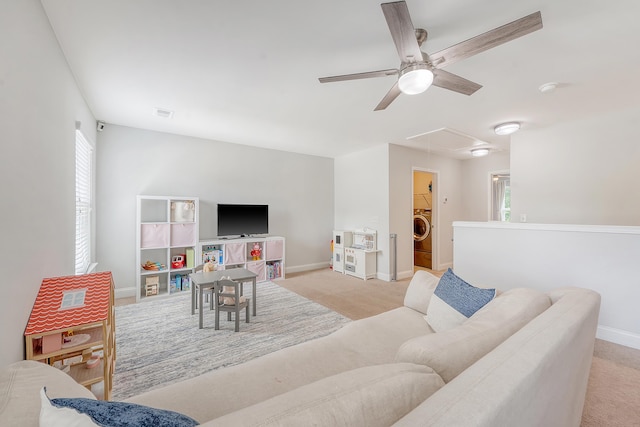 living area featuring washer / dryer, ceiling fan, attic access, and plenty of natural light