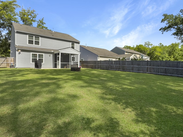 back of house with a sunroom, a fenced backyard, and a yard