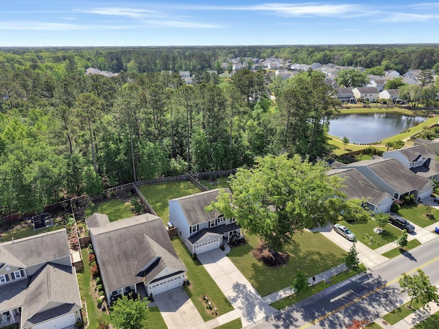 drone / aerial view featuring a water view, a residential view, and a wooded view
